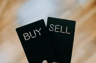 a hand holding a buy and sell card