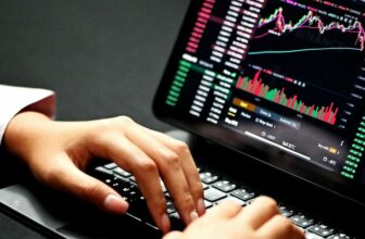 hands typing on laptop showing forex chart