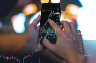hand holding out phone taping on screen showing trading chart